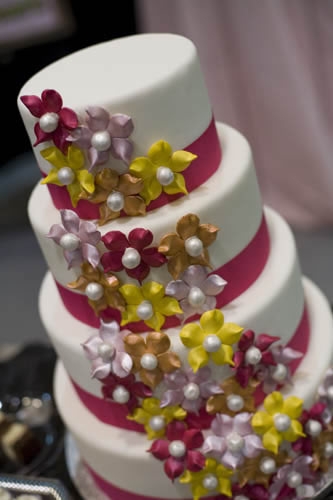 Dulce Desserts Pink and White Cake with Yellow, Brown, Pink, and Purple Flowers